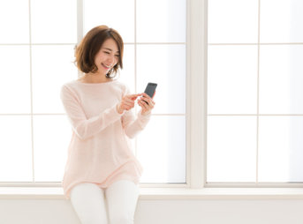 スマホを見る笑顔の女性