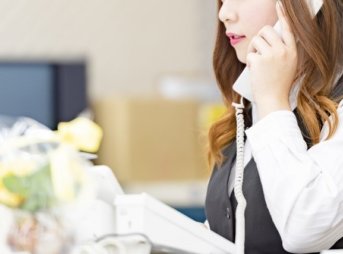 電話をかける女性スタッフ